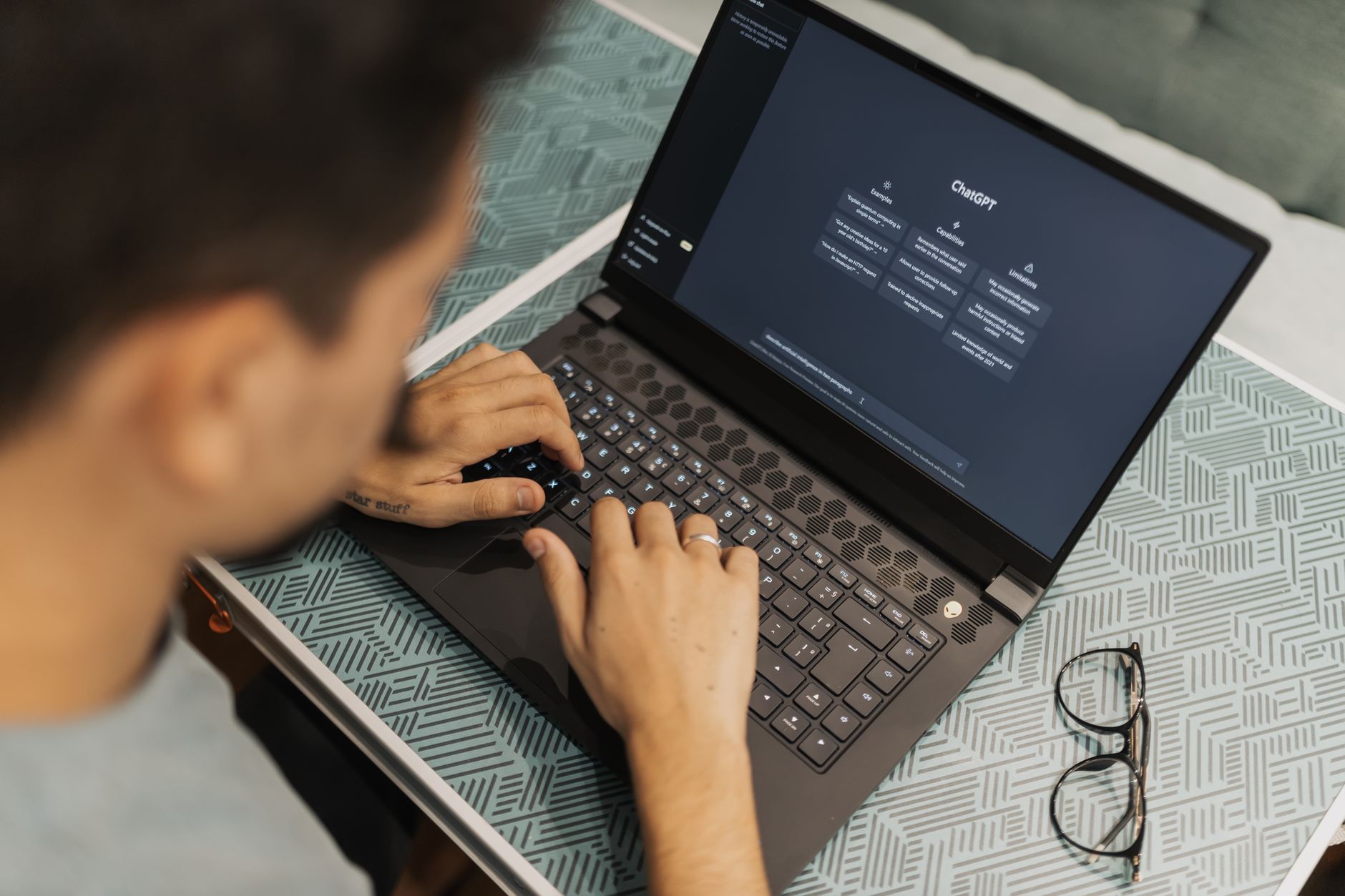 A person typing on a laptop with the ChatGPT start screen open